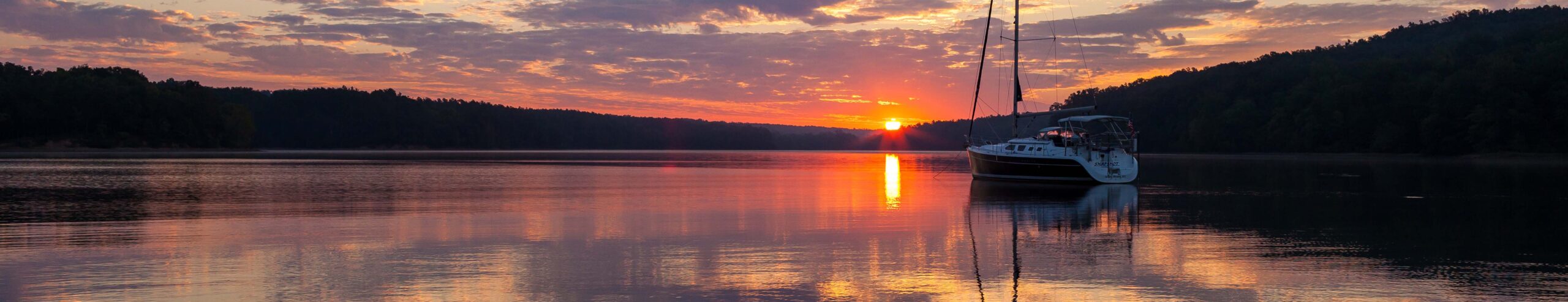 Image of boat on the lake at sunset.